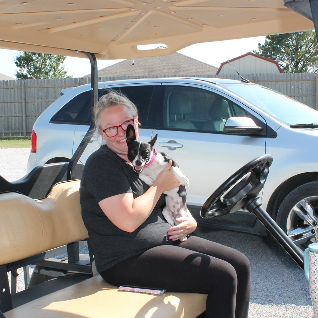 Team member on golf cart with dog at Glenpool Camper Sales & Storage