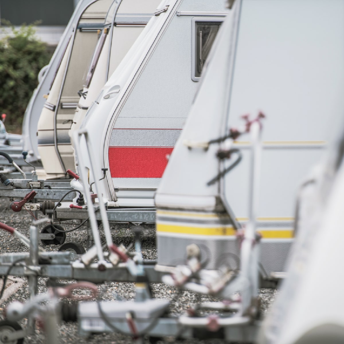 Row of parked travel trailers at secure RV storage facility in Glenpool OK